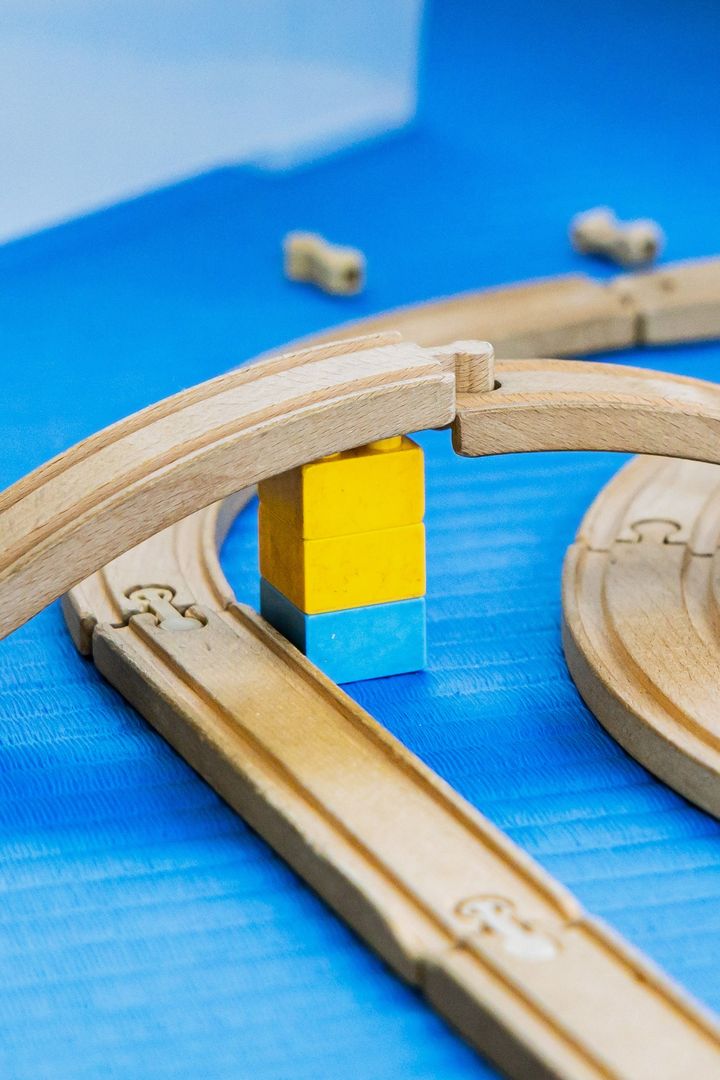 Un ponte di binari di legno appoggiato su mattoncini gialli e azzurri